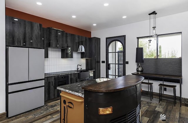 kitchen featuring hanging light fixtures, fridge, dark hardwood / wood-style flooring, and a kitchen island