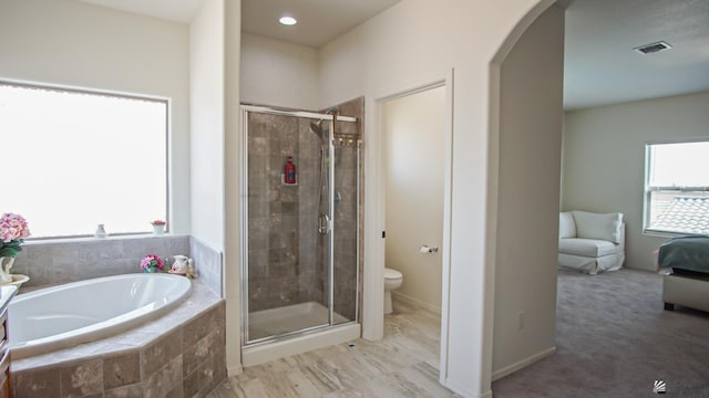 bathroom with toilet and shower with separate bathtub