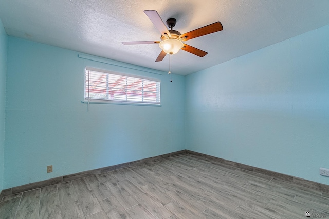 empty room with ceiling fan, a textured ceiling, and light hardwood / wood-style flooring