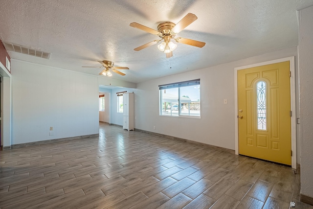 entryway featuring a textured ceiling and ceiling fan