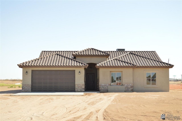 mediterranean / spanish-style home with a garage