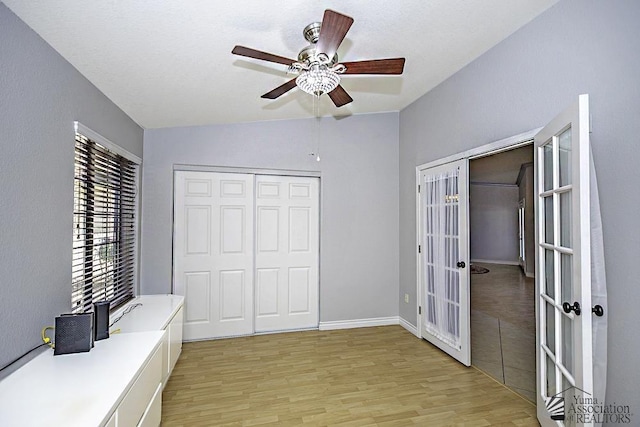 unfurnished office with french doors, ceiling fan, lofted ceiling, and light wood-type flooring