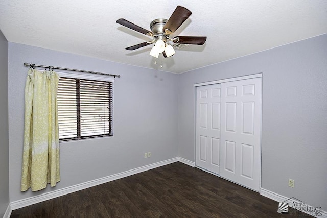 unfurnished bedroom featuring ceiling fan, dark hardwood / wood-style flooring, and a closet