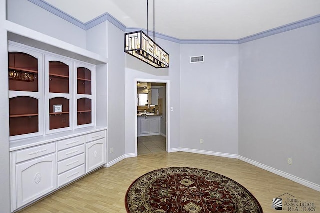 dining room with ornamental molding and light hardwood / wood-style floors