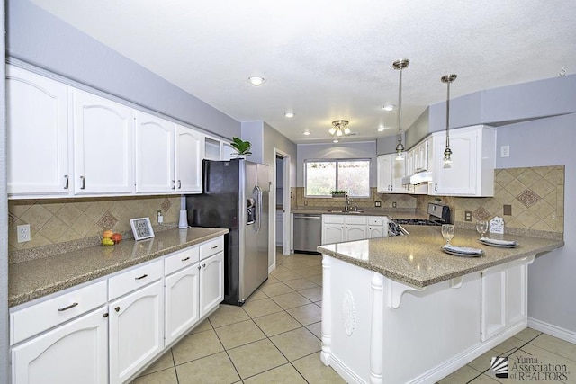 kitchen with white cabinetry, appliances with stainless steel finishes, decorative light fixtures, and kitchen peninsula