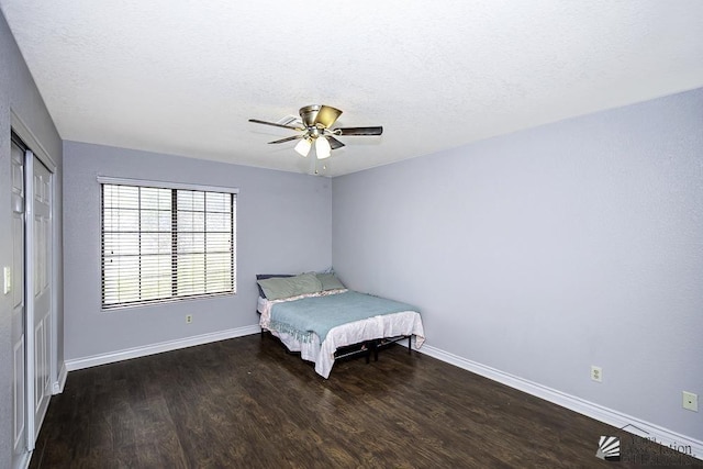 bedroom with a closet, dark hardwood / wood-style floors, a textured ceiling, and ceiling fan