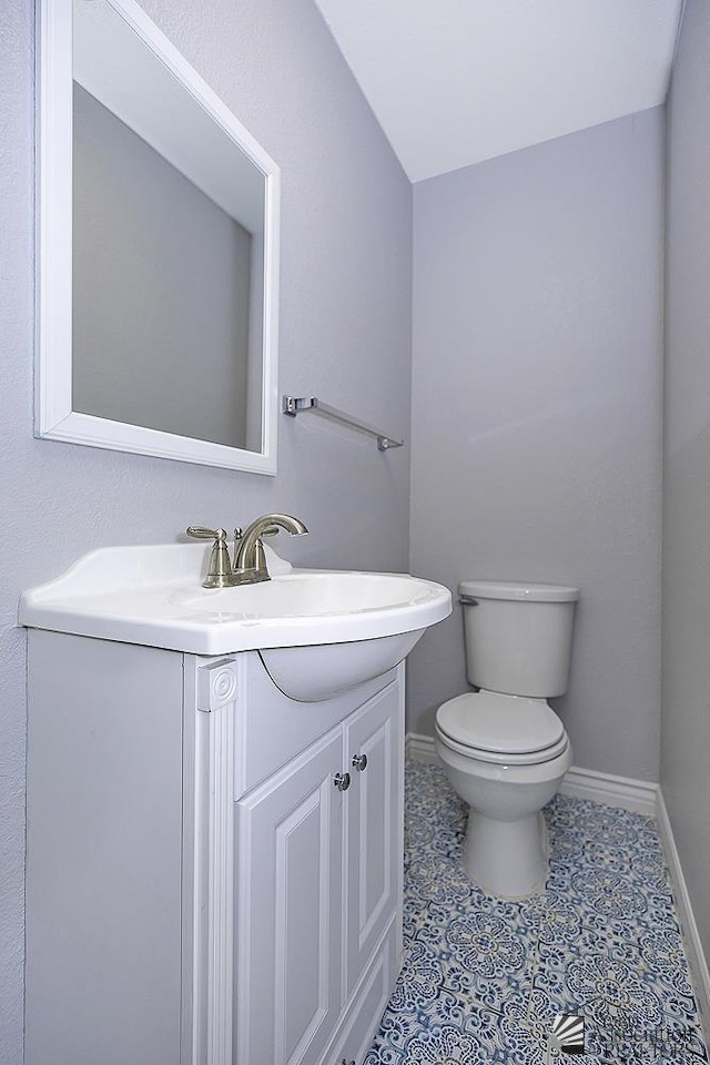 bathroom with tile patterned flooring, vanity, and toilet