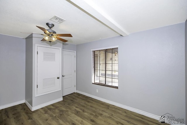 unfurnished bedroom featuring beamed ceiling, ceiling fan, dark hardwood / wood-style flooring, and a closet