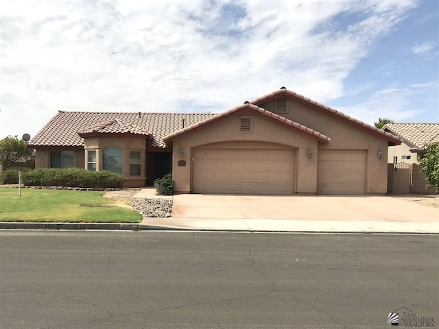 mediterranean / spanish-style house featuring a front yard and a garage