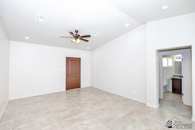 spare room with visible vents, lofted ceiling, baseboards, and ceiling fan