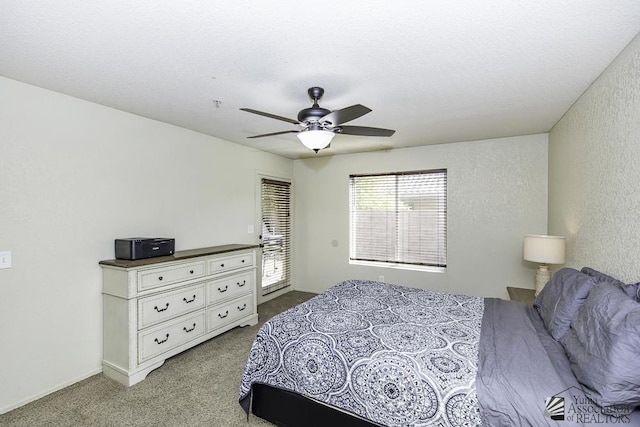 bedroom with a ceiling fan, carpet flooring, a textured wall, and a textured ceiling