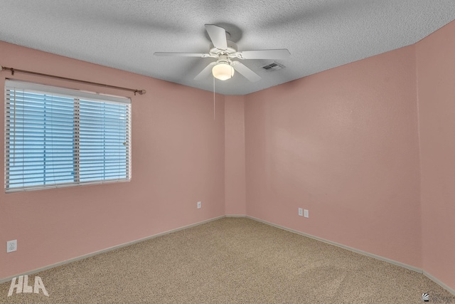 carpeted empty room featuring ceiling fan and a textured ceiling