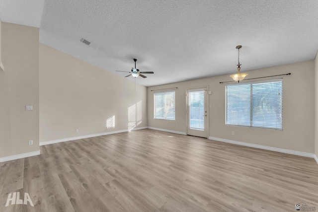 spare room featuring a textured ceiling, ceiling fan, and light hardwood / wood-style flooring