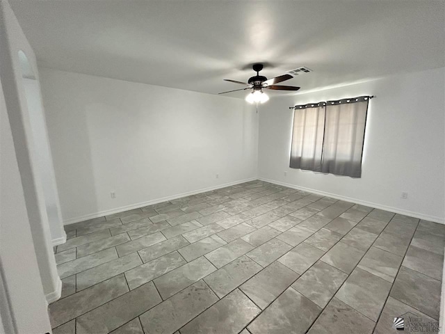 tiled spare room featuring ceiling fan