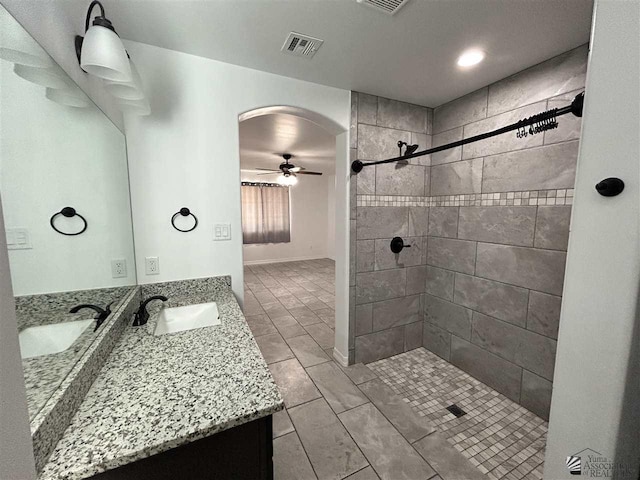 bathroom featuring a tile shower, vanity, tile patterned floors, and ceiling fan