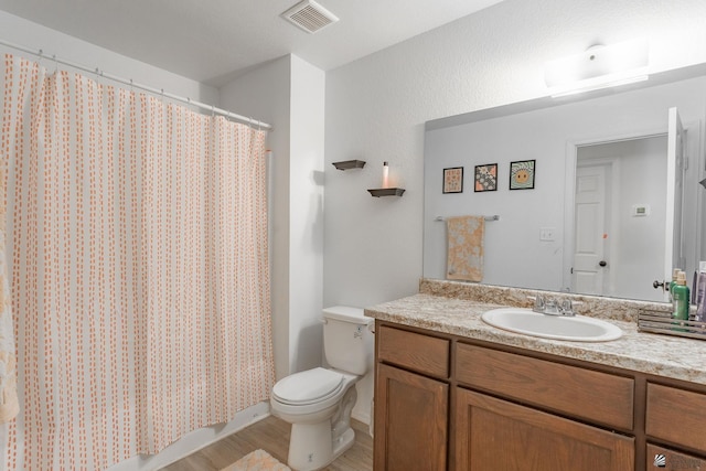 bathroom with hardwood / wood-style flooring, vanity, curtained shower, and toilet