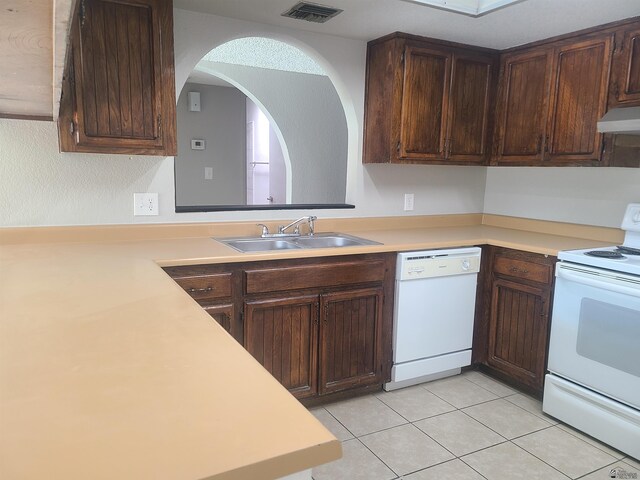 kitchen with white appliances, dark brown cabinets, and sink