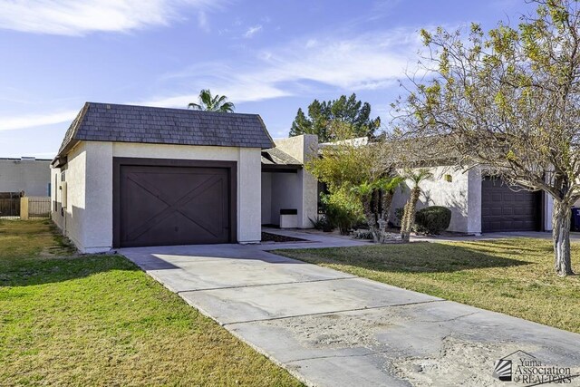 view of front of home with a front yard and a garage