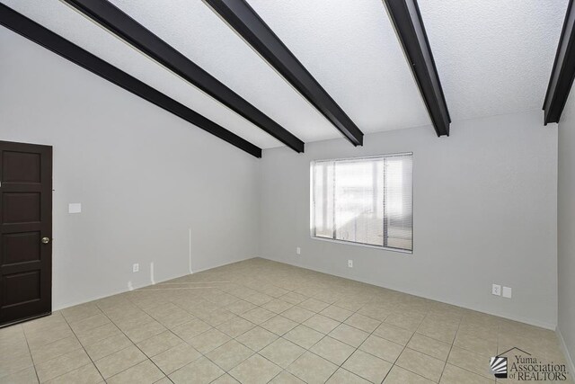 unfurnished room featuring lofted ceiling with beams and light tile patterned floors