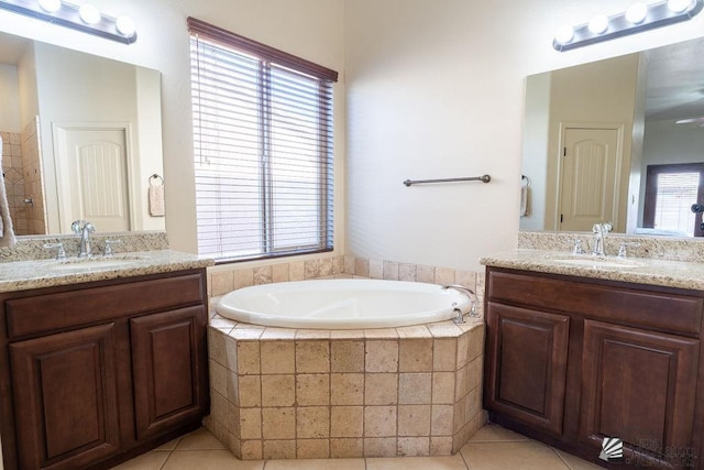 bathroom featuring tiled tub, tile patterned flooring, and vanity