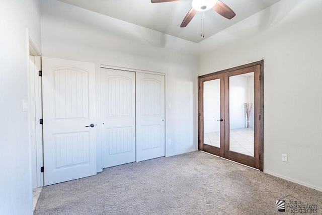 unfurnished bedroom featuring ceiling fan, a closet, light colored carpet, and french doors