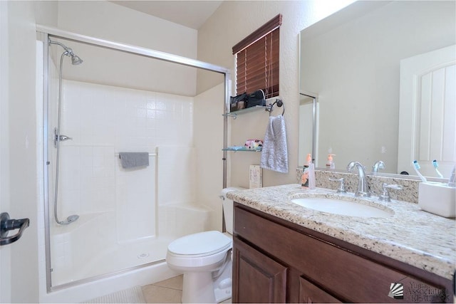 bathroom featuring tile patterned flooring, vanity, toilet, and a shower with shower door