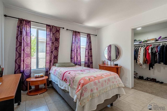 bedroom featuring a closet, light carpet, and multiple windows