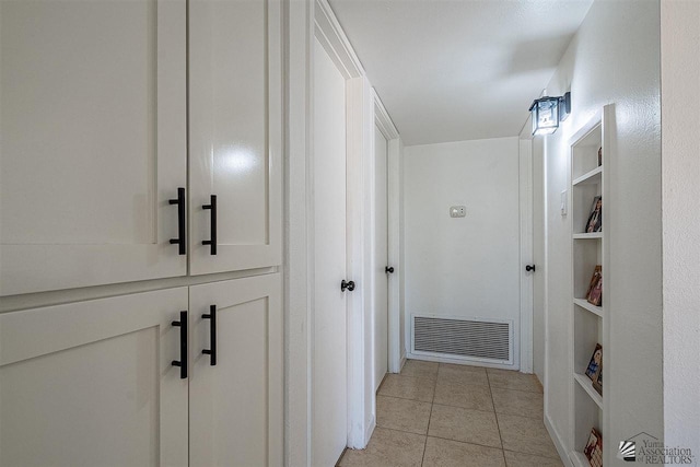 corridor featuring built in shelves and light tile patterned flooring