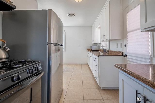 kitchen featuring white cabinetry, sink, black gas stove, extractor fan, and light tile patterned floors