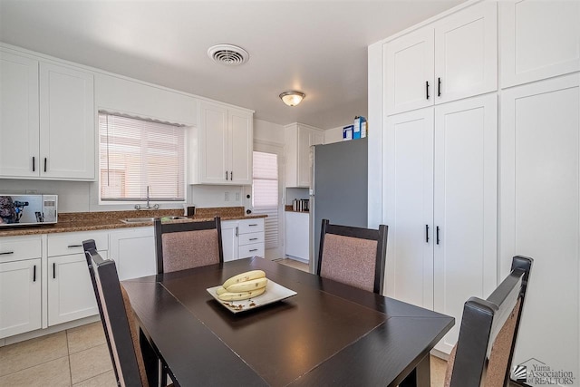 dining space featuring light tile patterned floors and sink