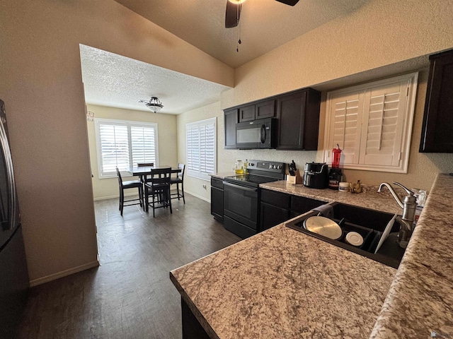 kitchen with lofted ceiling, sink, electric range, dark hardwood / wood-style floors, and ceiling fan