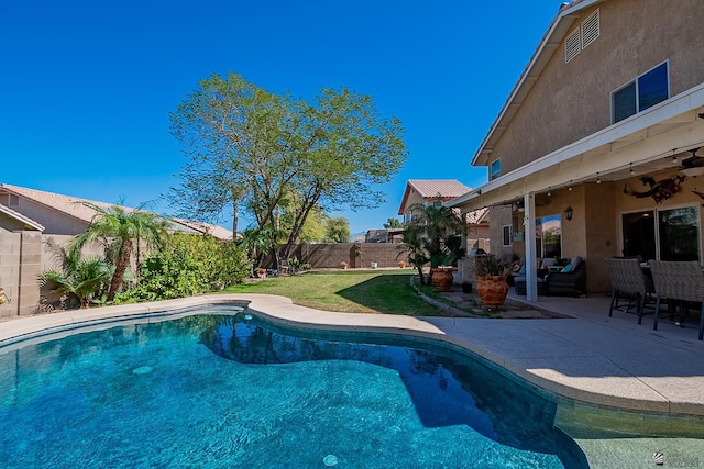 view of pool with a patio, a fenced backyard, a ceiling fan, a yard, and a fenced in pool