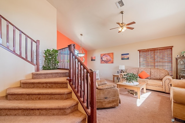 living area featuring carpet, visible vents, stairway, a ceiling fan, and high vaulted ceiling