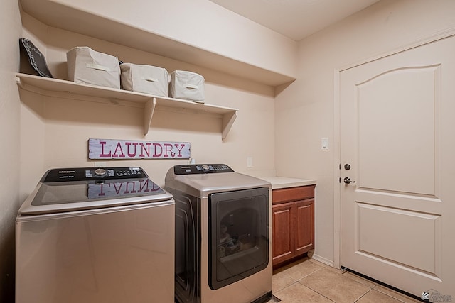 clothes washing area featuring cabinet space, light tile patterned floors, and separate washer and dryer