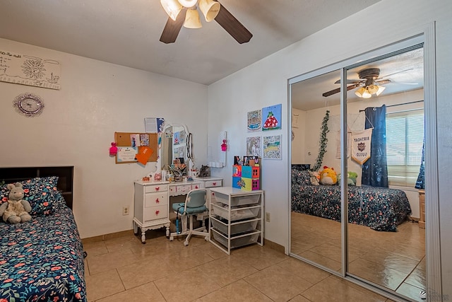 tiled bedroom with a ceiling fan, baseboards, and a closet