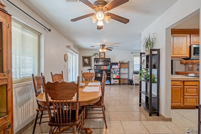 dining room with ceiling fan, visible vents, and light tile patterned flooring