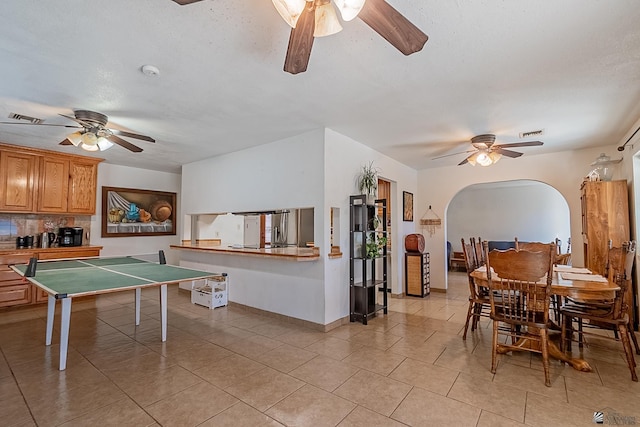 dining area featuring arched walkways, visible vents, a ceiling fan, and light tile patterned floors