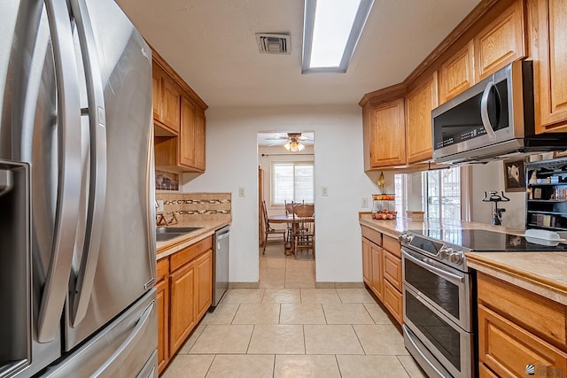 kitchen featuring visible vents, ceiling fan, light countertops, light tile patterned flooring, and stainless steel appliances