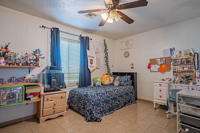 bedroom featuring light tile patterned floors, baseboards, visible vents, ceiling fan, and a textured ceiling