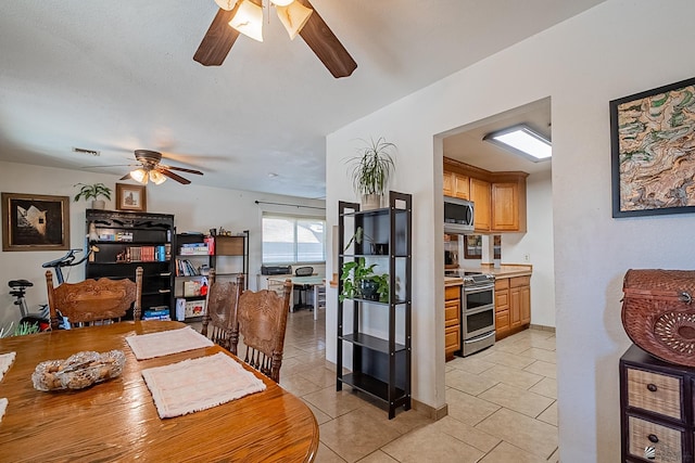 dining space featuring light tile patterned floors, visible vents, and ceiling fan