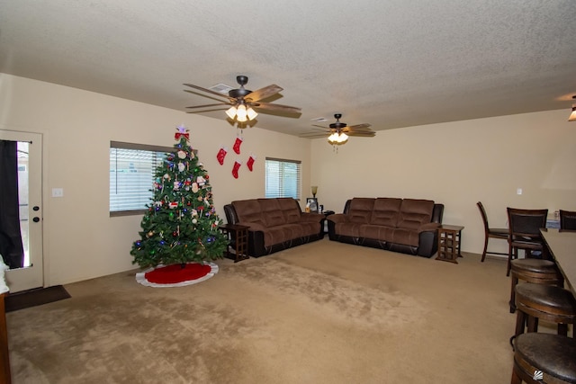 living room with ceiling fan, carpet, and a textured ceiling