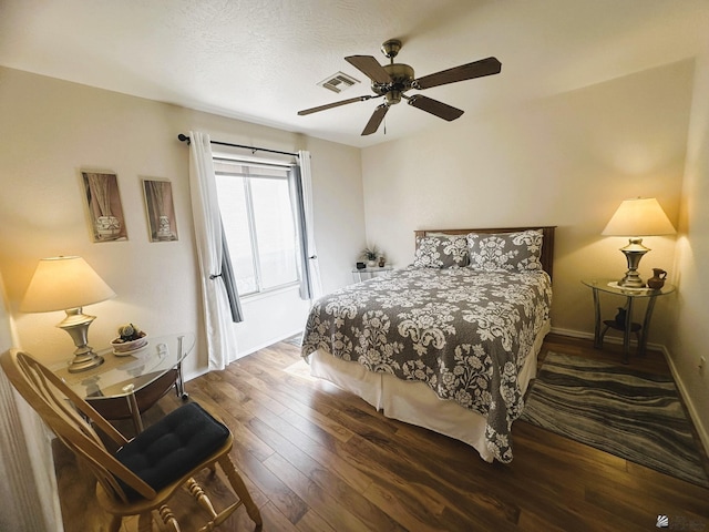 bedroom with hardwood / wood-style flooring, baseboards, visible vents, and ceiling fan