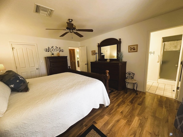 bedroom featuring ceiling fan, wood finished floors, visible vents, and connected bathroom