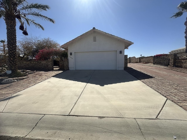 garage with driveway and fence