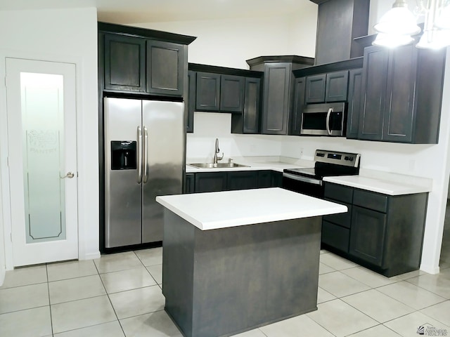 kitchen featuring sink, light tile patterned floors, appliances with stainless steel finishes, hanging light fixtures, and a kitchen island