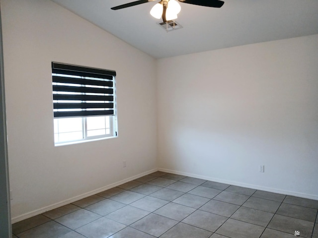 spare room featuring vaulted ceiling, light tile patterned floors, and ceiling fan