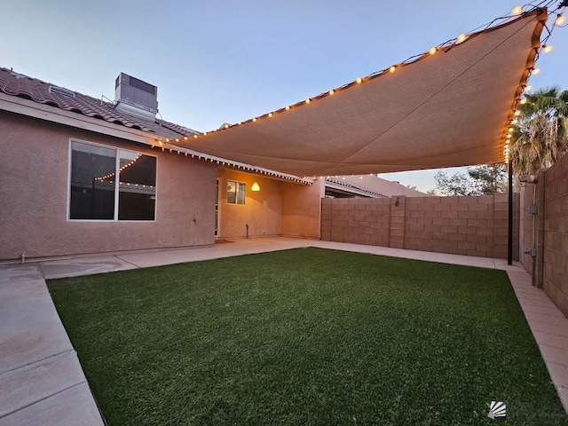 view of yard featuring central AC, fence, and a patio