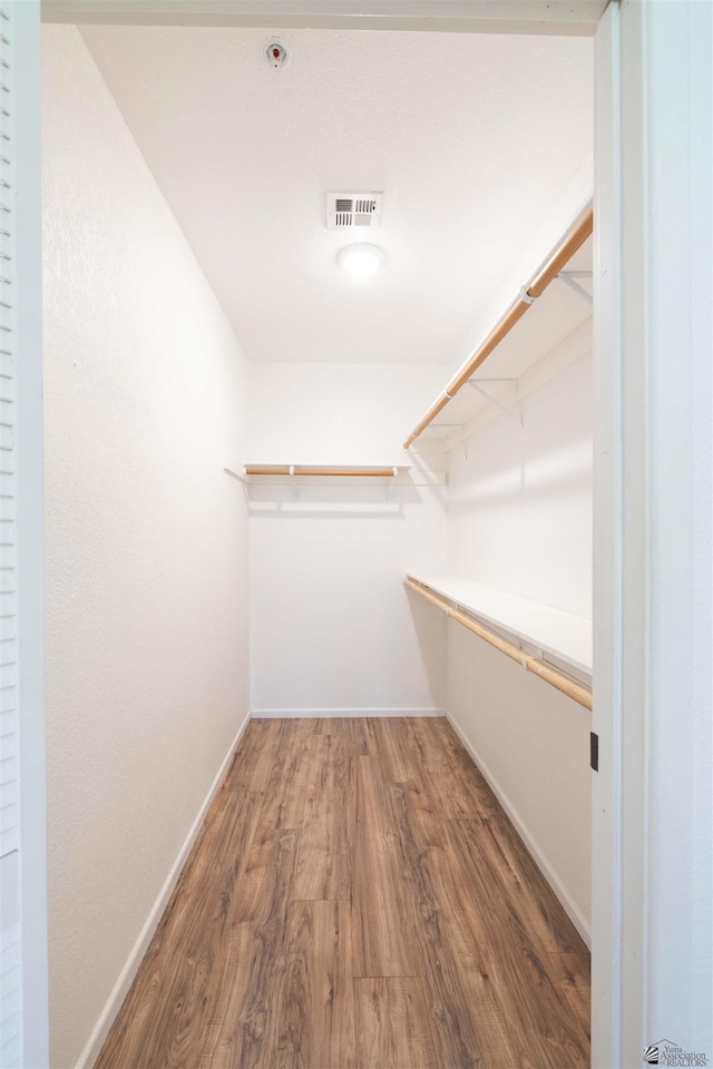 walk in closet featuring dark wood-style floors and visible vents