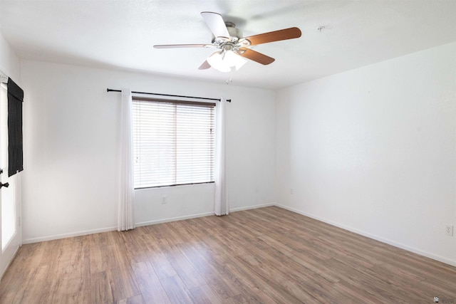 unfurnished room with a ceiling fan, baseboards, and wood finished floors