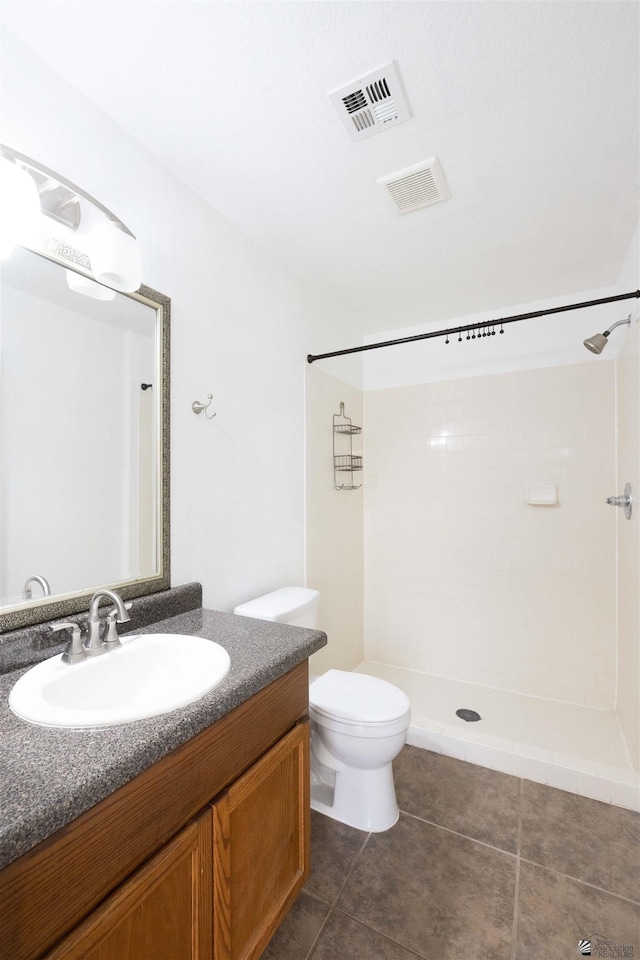 bathroom with visible vents, vanity, toilet, and tile patterned floors